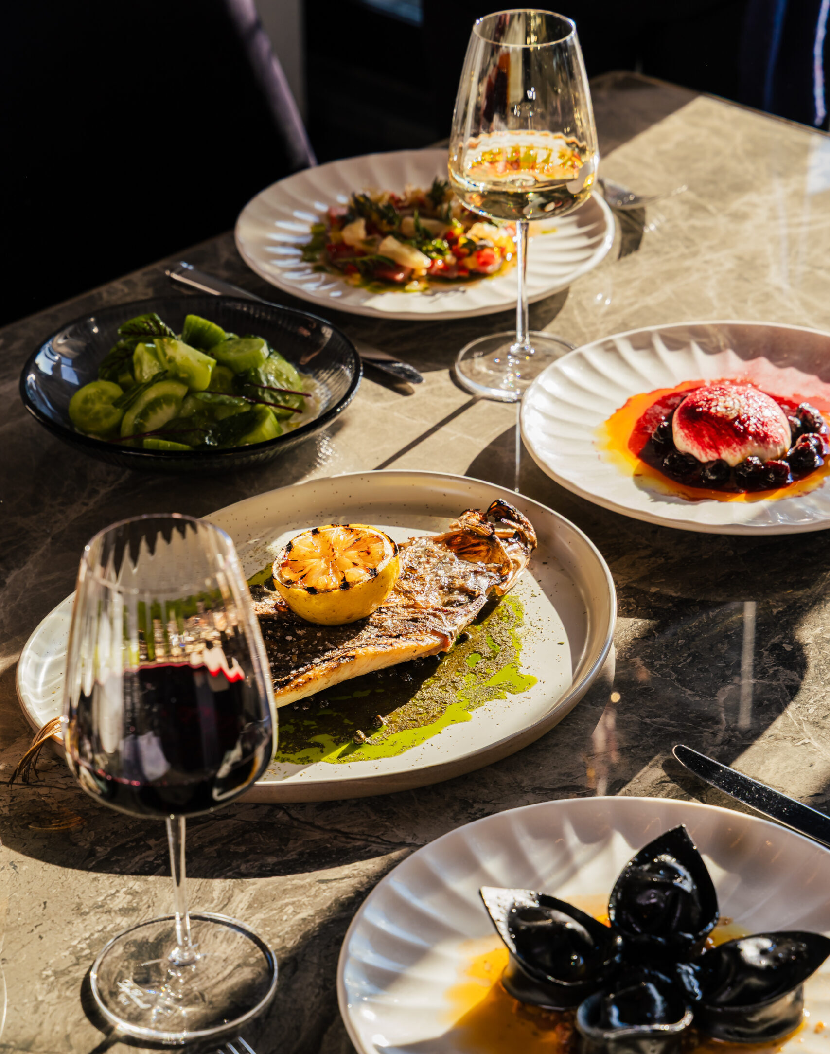 an array or seafood matched with wine. Sunshine is showering the table from a harbourside window